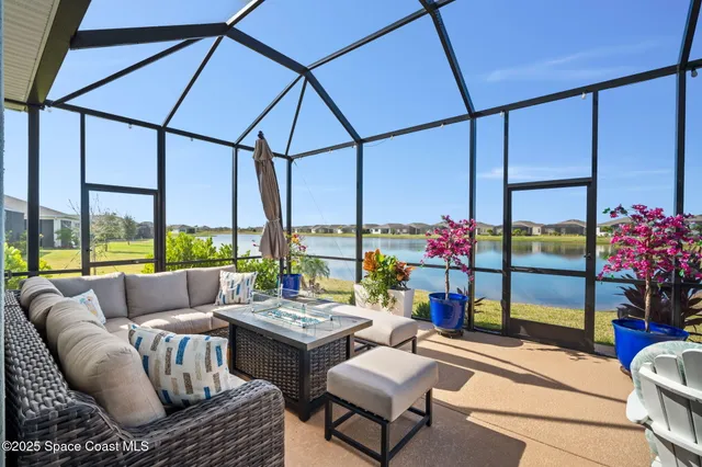 a living room with patio furniture and a floor to ceiling window
