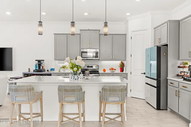 a kitchen with stainless steel appliances kitchen island granite countertop a refrigerator and a stove top oven