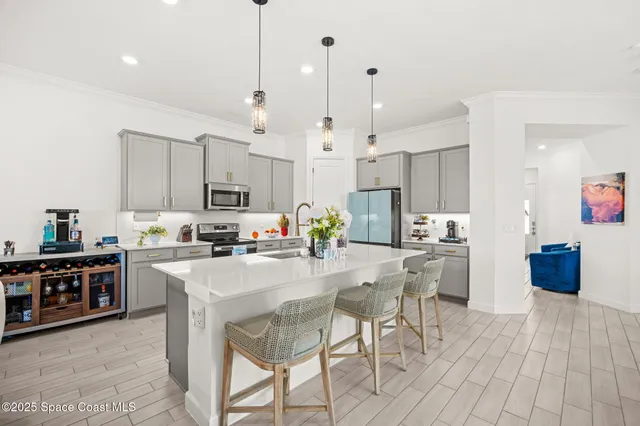 a kitchen with stainless steel appliances kitchen island granite countertop a stove a sink a refrigerator and a cabinets