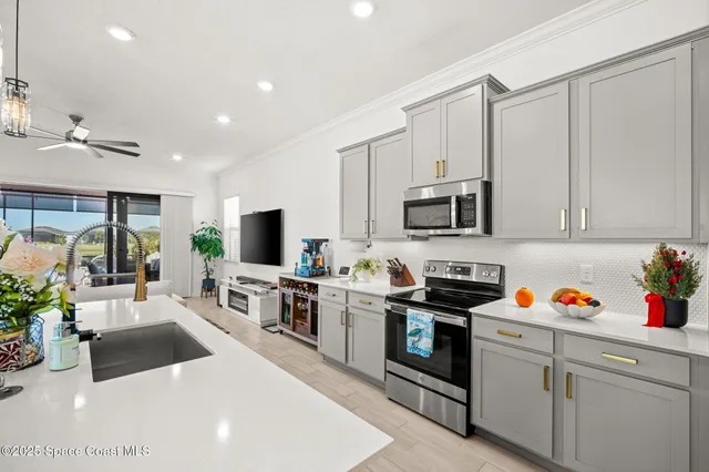 a kitchen with stainless steel appliances a stove a sink a microwave a refrigerator and cabinets