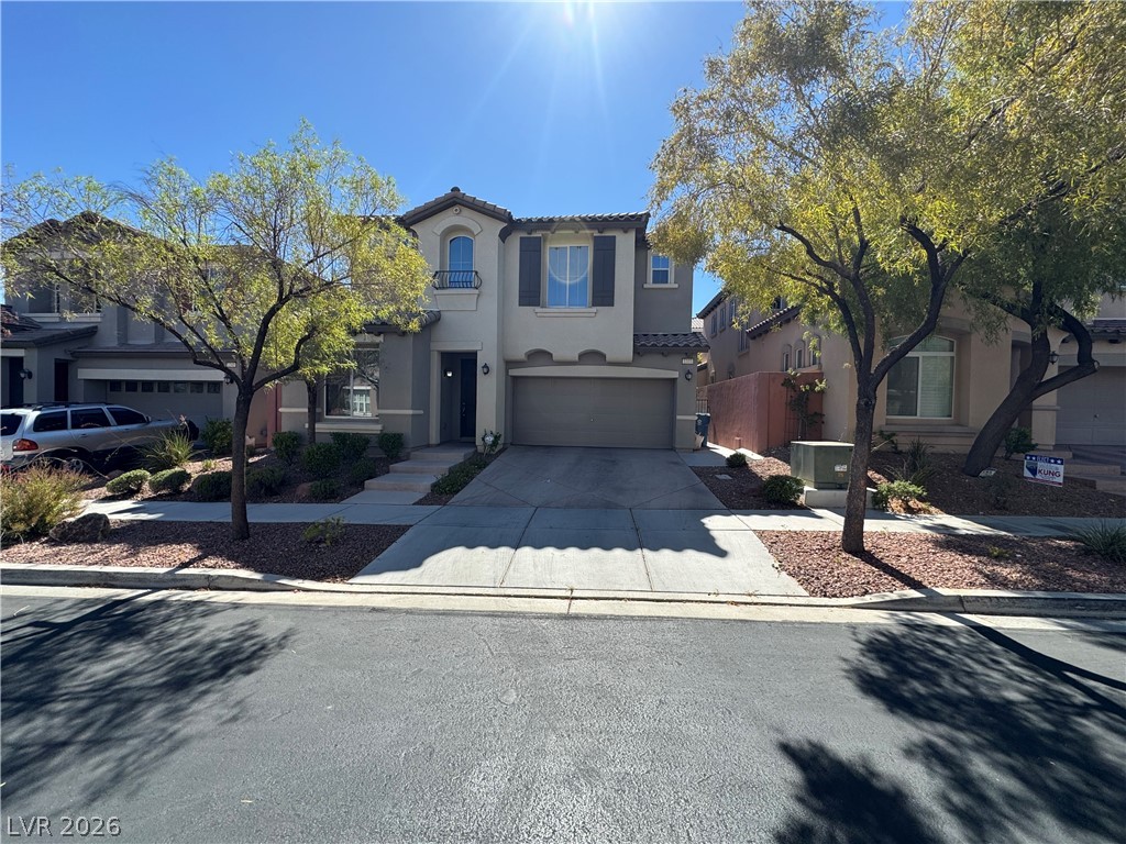1333 Jamesbury Road Las Vegas, NV 89135 - Photo 1 of 43 A welcoming facade with a garage, complemented by mature trees and a well-maintained concrete driveway.