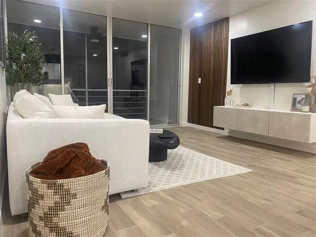 a living room with a flat screen tv and a floor to ceiling window