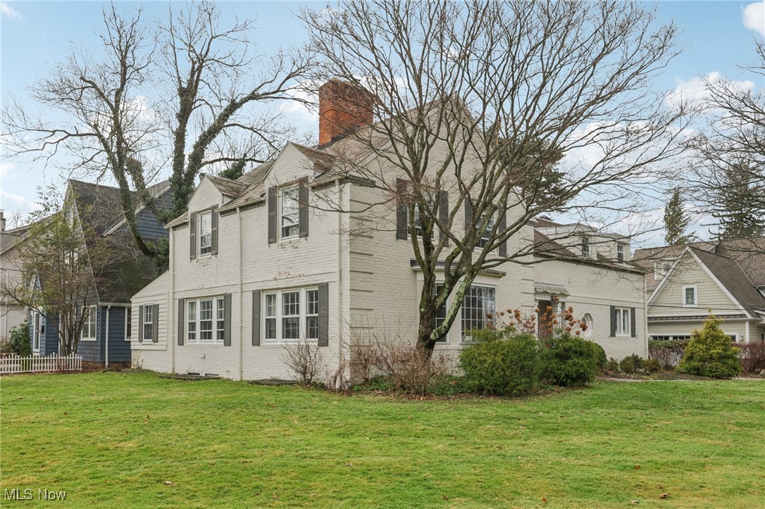 View of side of property with brick facade and a chimney