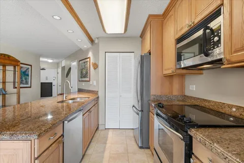 a kitchen with stainless steel appliances granite countertop a refrigerator stove and microwave