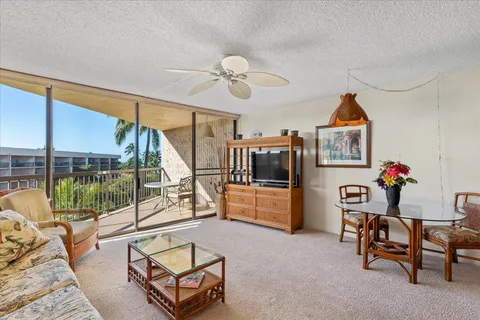 a living room with furniture a flat screen tv and a floor to ceiling window