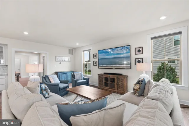 a kitchen with stainless steel appliances kitchen island granite countertop a stove a refrigerator a kitchen island a dining table and chairs with wooden floor