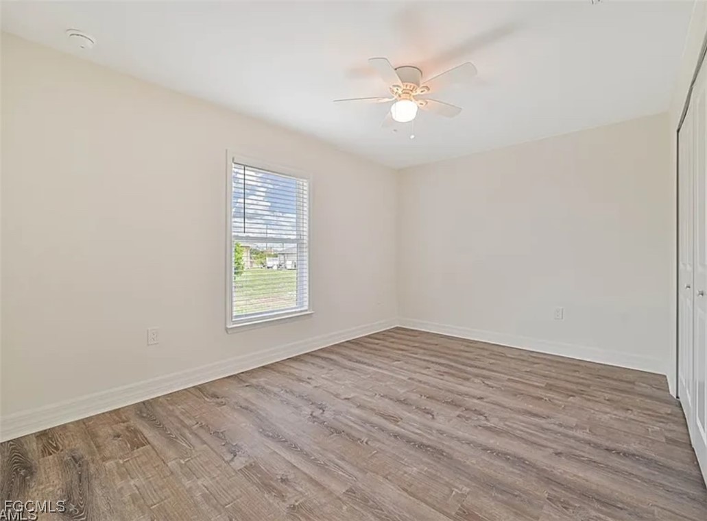 4414 28th Street Southwest Lehigh Acres, FL 33973 - Photo 14 of 29 a view of an empty room with wooden floor and a window