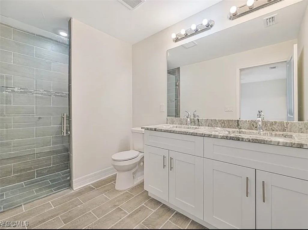 4414 28th Street Southwest Lehigh Acres, FL 33973 - Photo 15 of 29 a bathroom with a granite countertop toilet sink and mirror