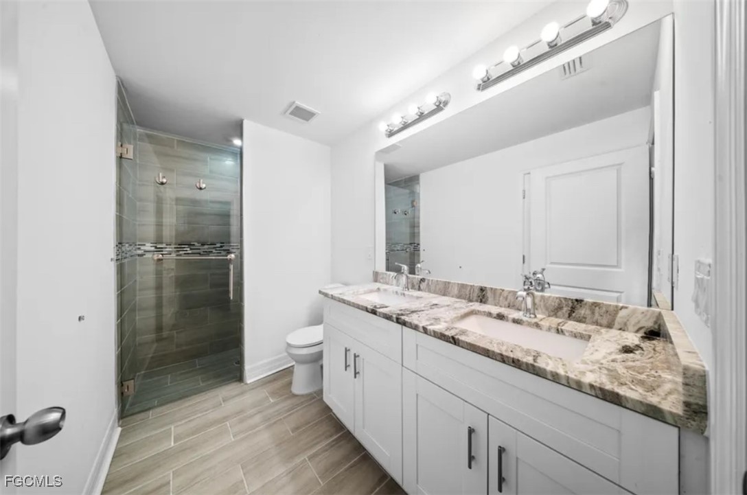 4414 28th Street Southwest Lehigh Acres, FL 33973 - Photo 20 of 29 a spacious bathroom with a granite countertop sink a toilet and shower