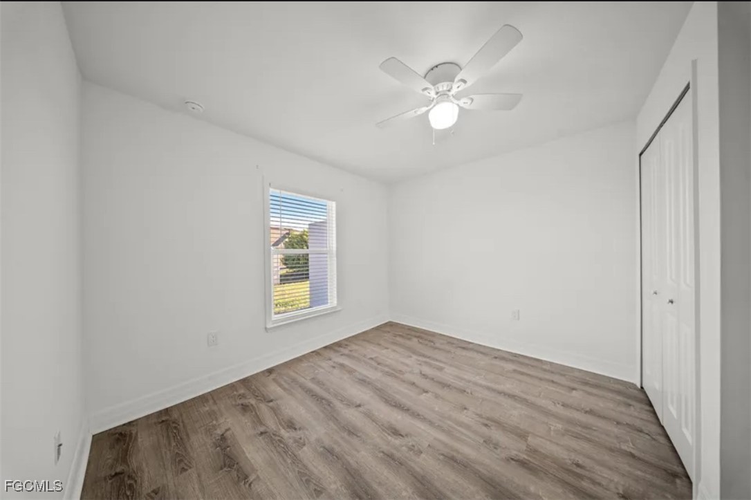 4414 28th Street Southwest Lehigh Acres, FL 33973 - Photo 22 of 29 a view of an empty room with wooden floor and a window