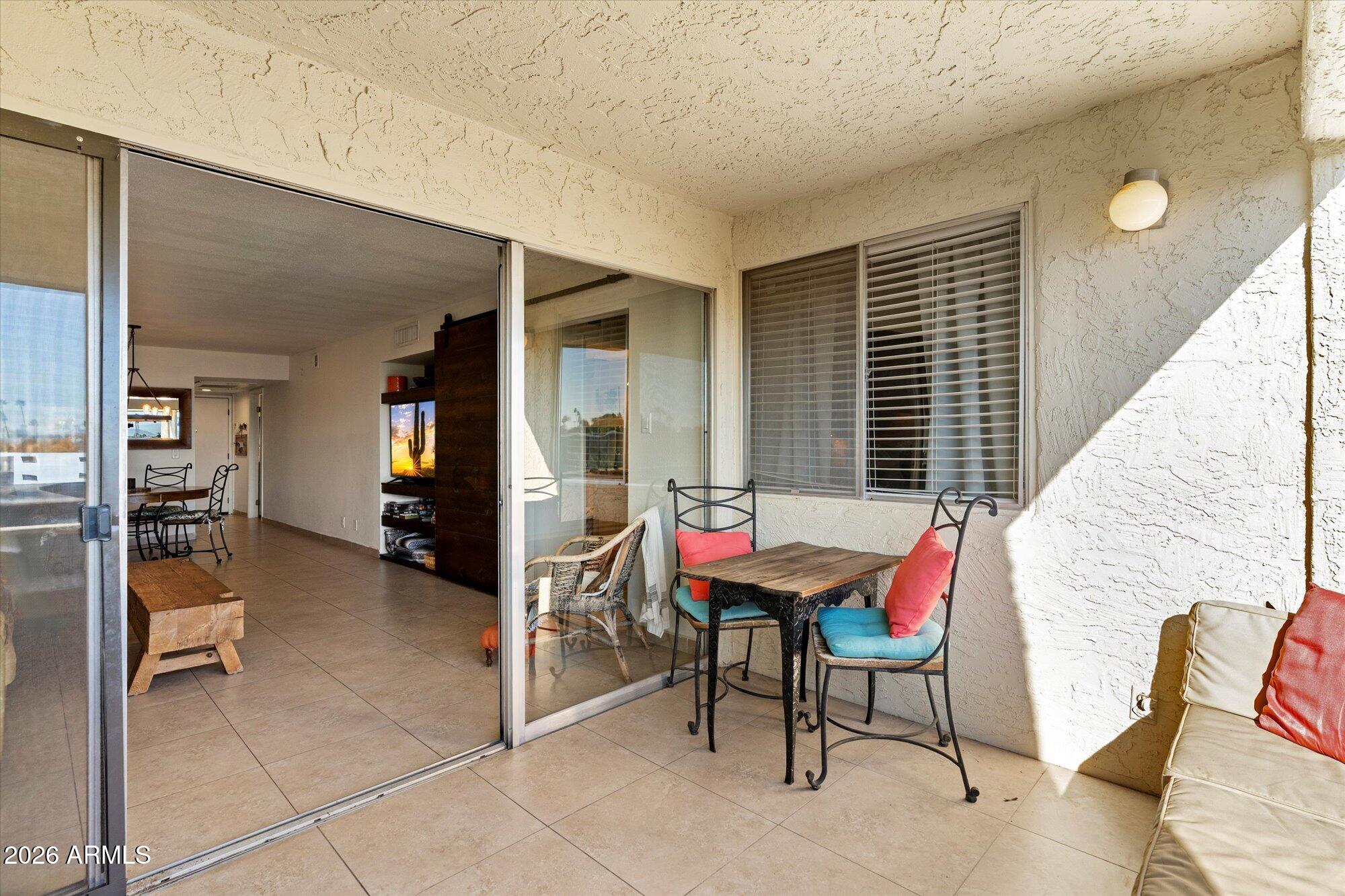 7625 East Camelback Road, Unit B325 Scottsdale, AZ 85251 - Photo 11 of 24 a balcony with furniture and book shelf