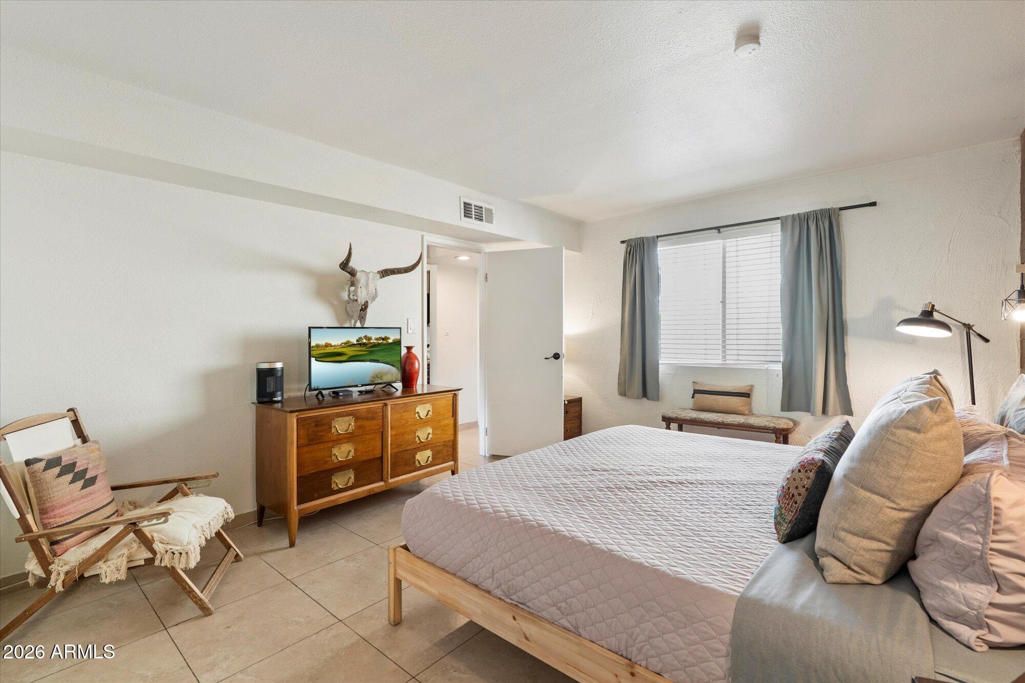 7625 East Camelback Road, Unit B325 Scottsdale, AZ 85251 - Photo 13 of 24 a bedroom with a bed and dresser