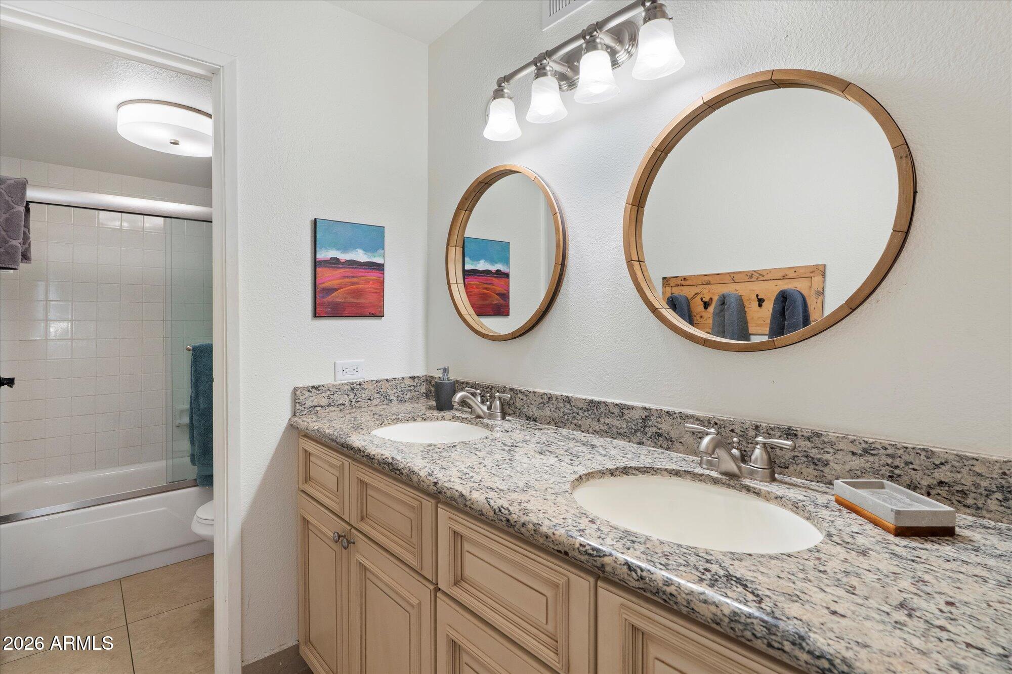 7625 East Camelback Road, Unit B325 Scottsdale, AZ 85251 - Photo 14 of 24 a bathroom with a granite countertop double vanity and a mirror