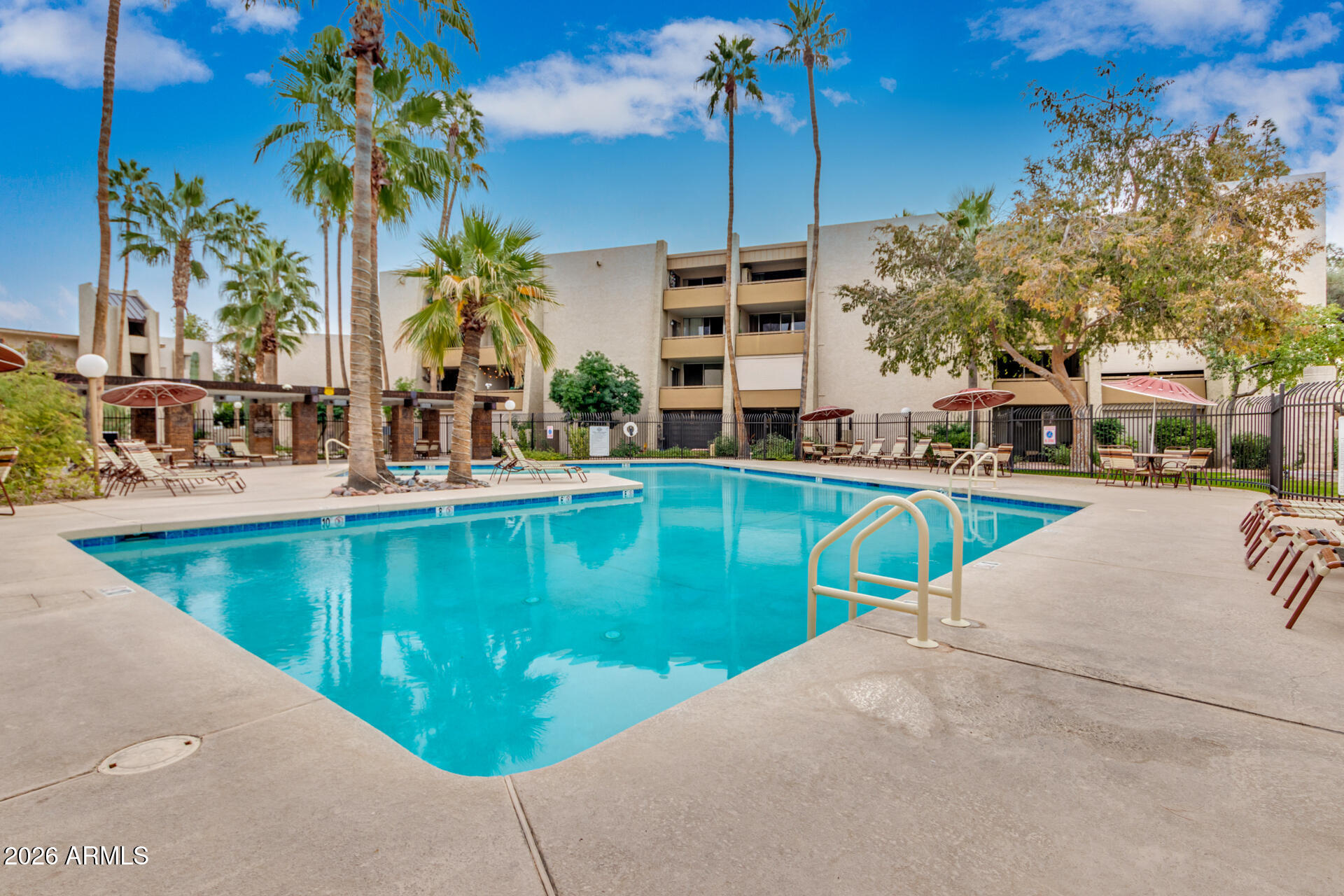 7625 East Camelback Road, Unit B325 Scottsdale, AZ 85251 - Photo 20 of 24 a view of a swimming pool with a lawn chairs