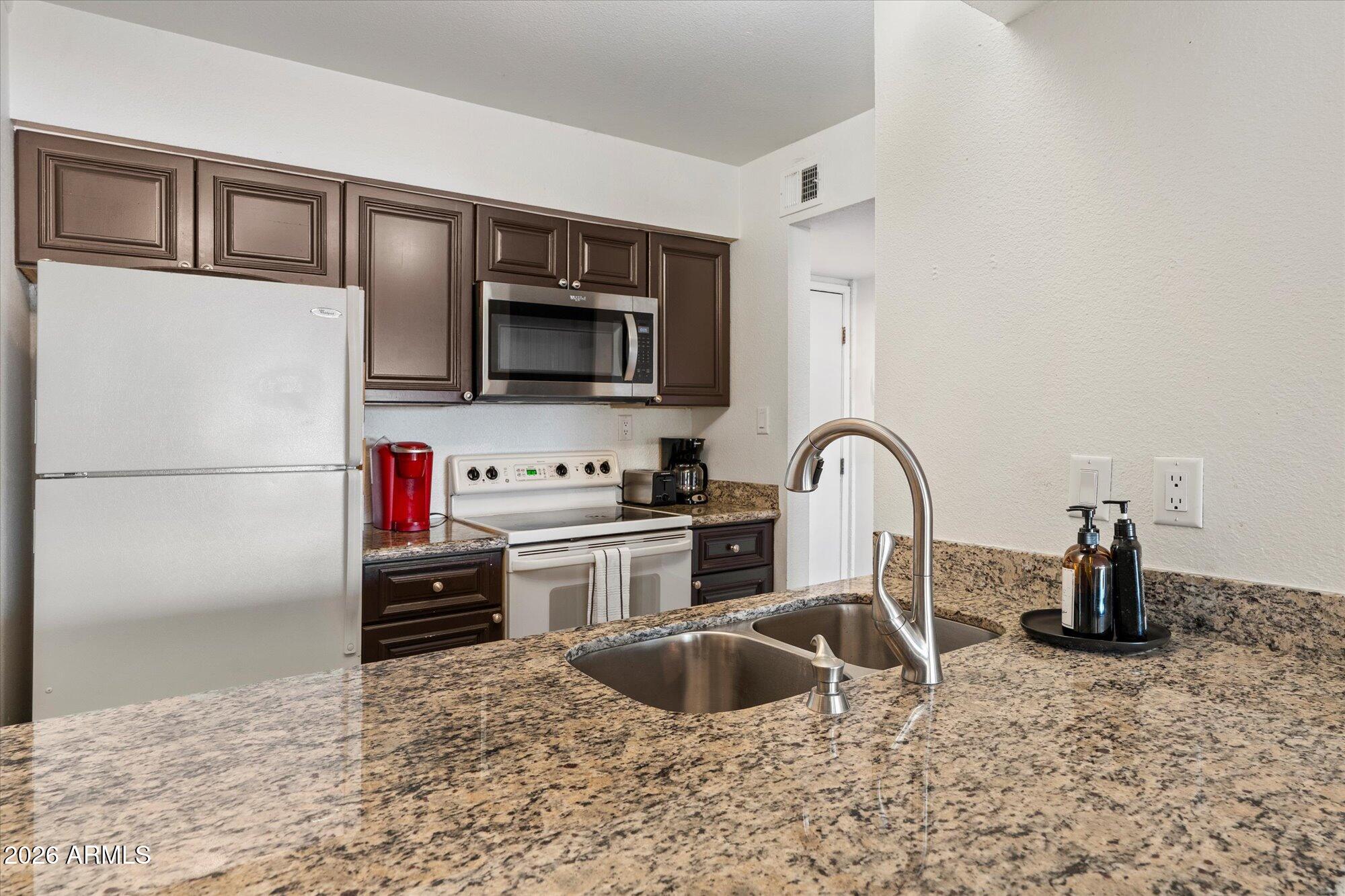 7625 East Camelback Road, Unit B325 Scottsdale, AZ 85251 - Photo 2 of 24 a kitchen with sink a stove and refrigerator