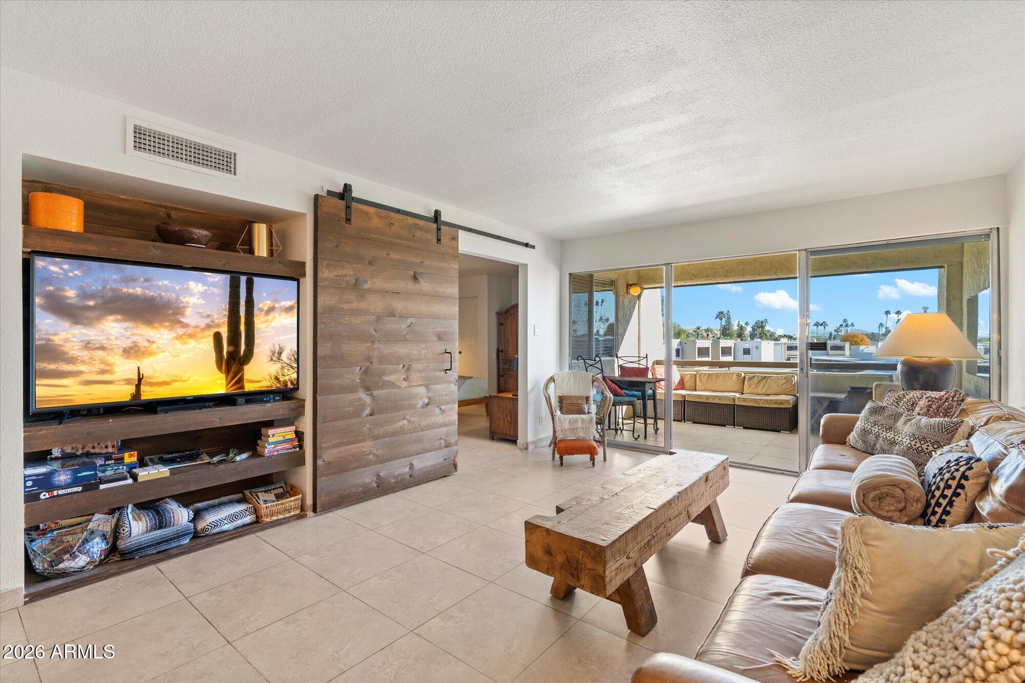 7625 East Camelback Road, Unit B325 Scottsdale, AZ 85251 - Photo 7 of 24 a living room with furniture and a flat screen tv