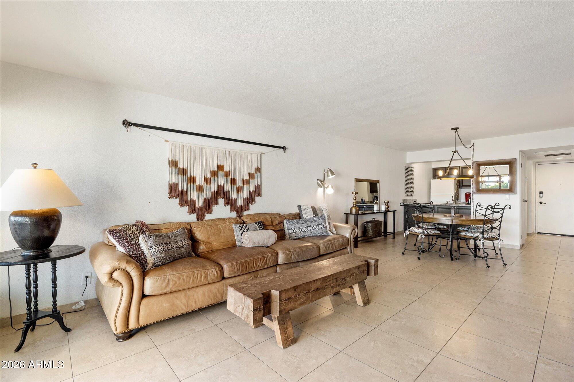 7625 East Camelback Road, Unit B325 Scottsdale, AZ 85251 - Photo 8 of 24 a living room with furniture and a dining table with kitchen view