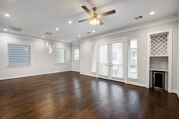 an empty room with wooden floor fireplace and windows