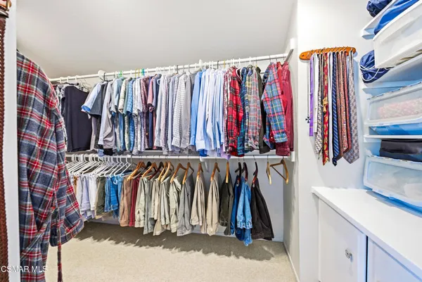 a view of walk in closet with clothes