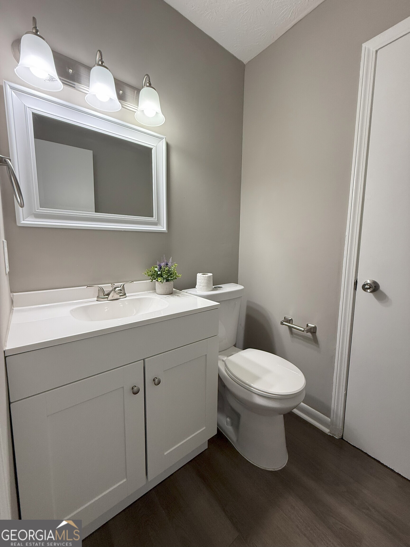 516 Harris Street Monroe, GA 30655 - Photo 16 of 25 a bathroom with a toilet sink and mirror