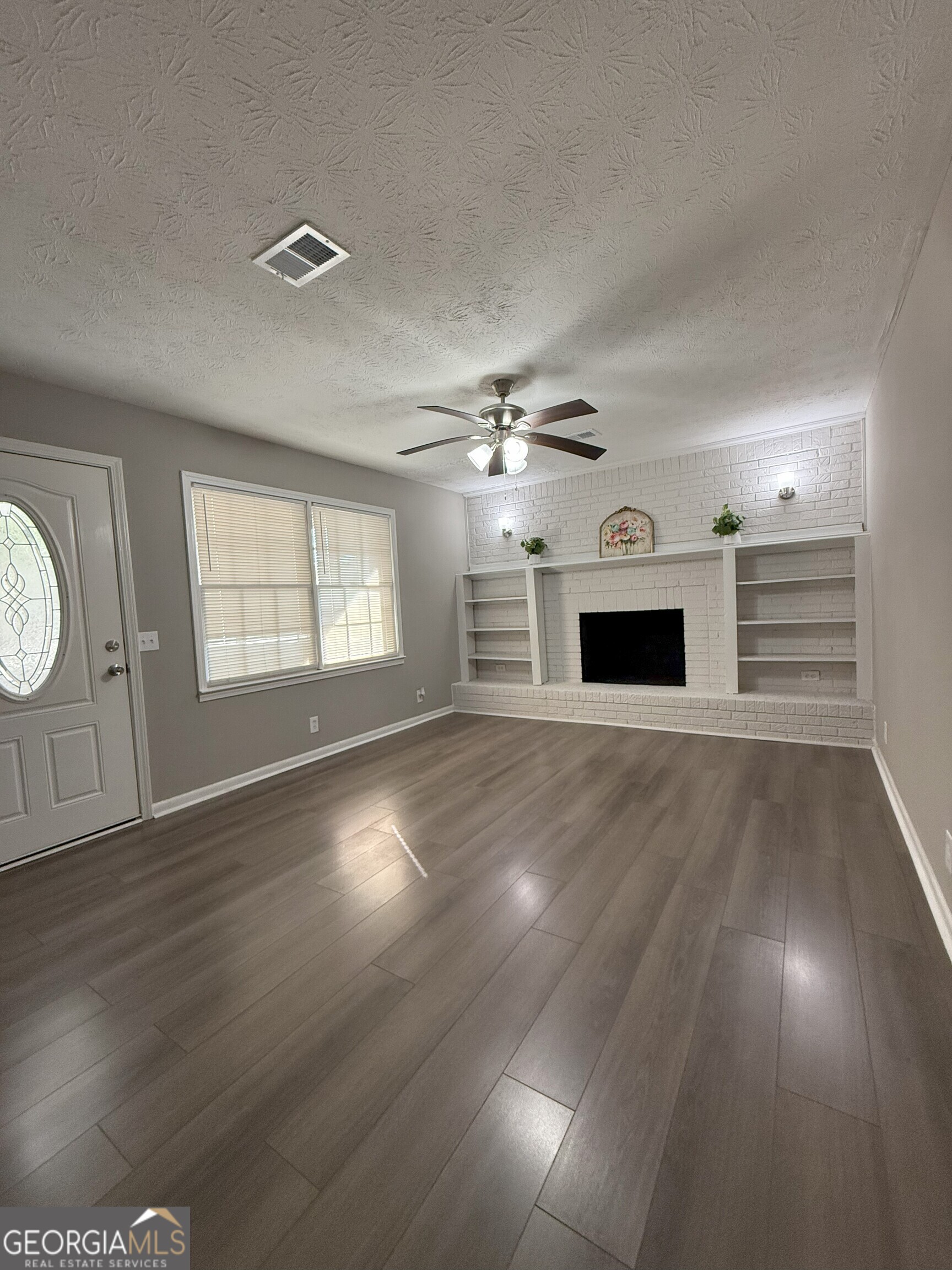 516 Harris Street Monroe, GA 30655 - Photo 5 of 25 a view of an empty room with window and wooden floor
