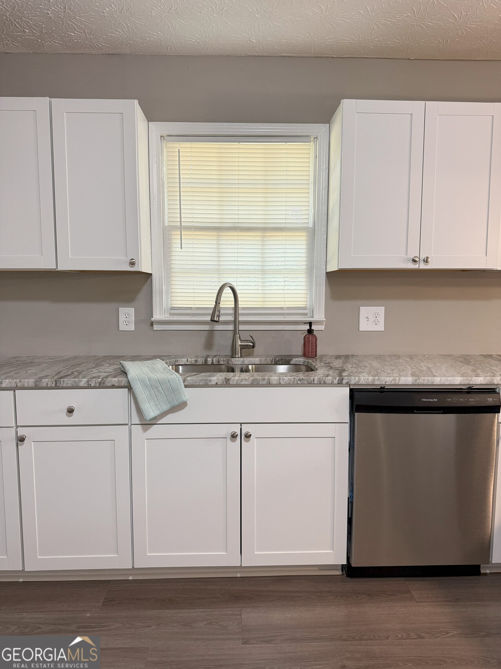 516 Harris Street Monroe, GA 30655 - Photo 7 of 25 a kitchen with stainless steel appliances granite countertop a sink stove and white cabinets