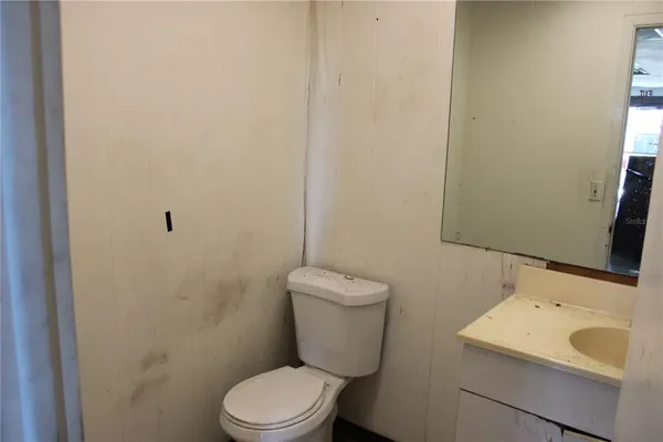 a bathroom with a toilet sink and mirror