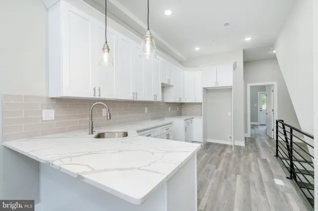 a kitchen with a sink a refrigerator and cabinets