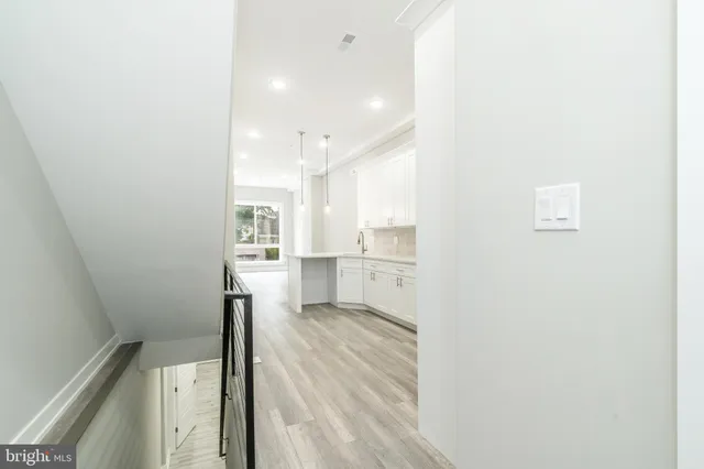 an empty room with wooden floor and a ceiling fan