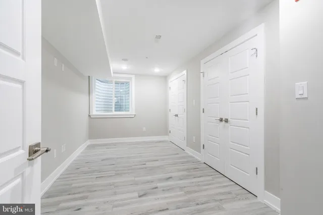 a view of an empty walk in closet with wooden floor
