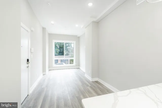 a view of a livingroom with wooden floor and a window