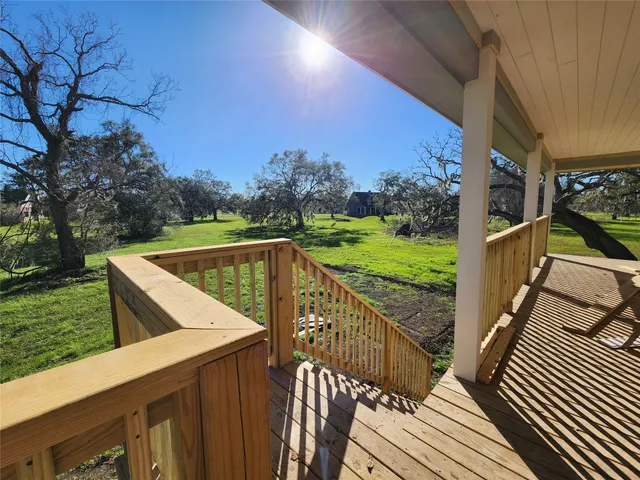 a view of a balcony with wooden floor and fence
