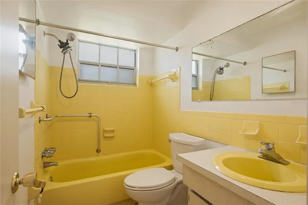 a bathroom with a sink a mirror toilet and bathtub