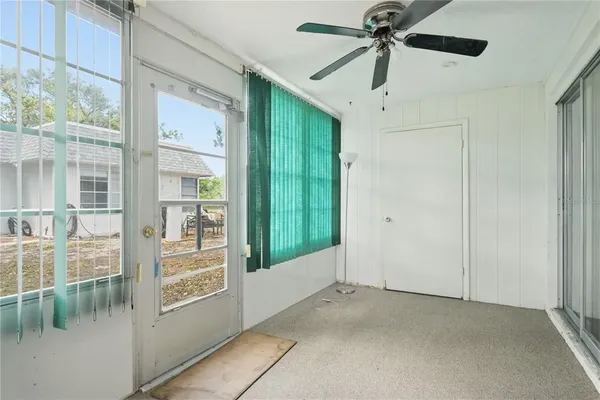 a view of a livingroom with a ceiling fan and window
