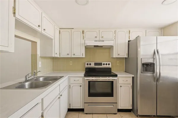 a kitchen with cabinets stainless steel appliances and a sink