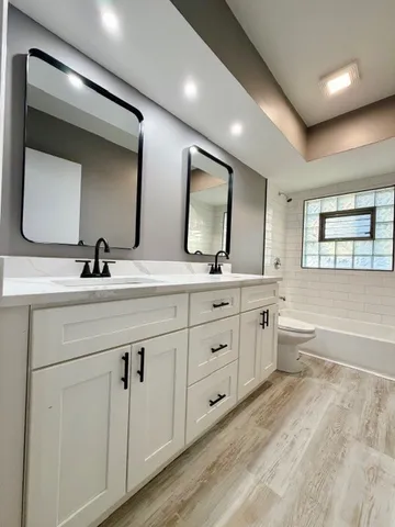 a bathroom with double sink and a mirror