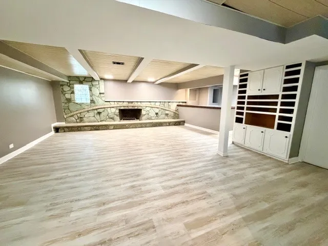 an empty room with wooden floor windows and cabinet