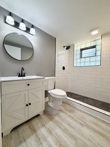 a bathroom with a toilet a sink and mirror