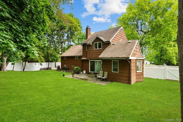 a front view of house with yard and trees in the background