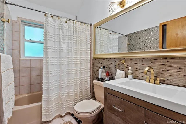 a bathroom with a sink a toilet and shower curtain