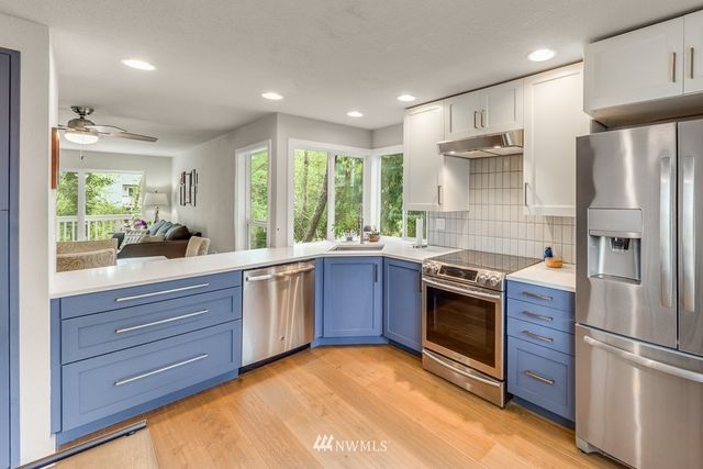 a kitchen with stainless steel appliances granite countertop a refrigerator and a sink