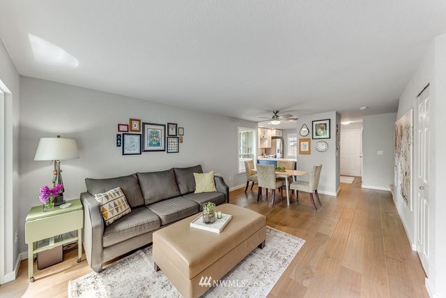 a living room with furniture and a dining table with wooden floor