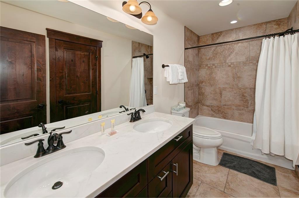 767 Independence Road, Unit 3A Keystone, CO 80435 - Photo 19 of 35 a bathroom with a double vanity sink toilet mirror and shower