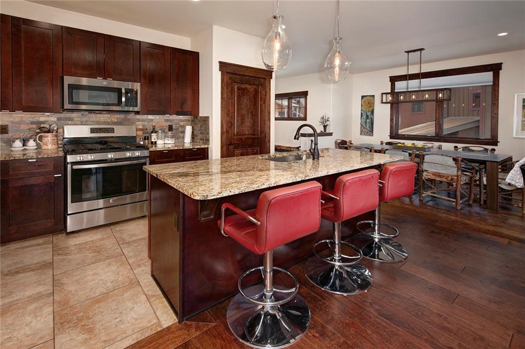 767 Independence Road, Unit 3A Keystone, CO 80435 - Photo 10 of 35 a large kitchen with stainless steel appliances a table chairs and a refrigerator