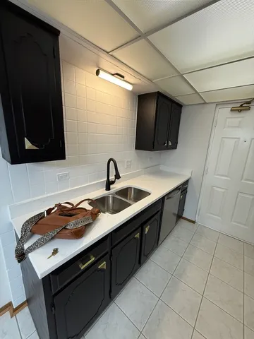 a kitchen with a sink a refrigerator and cabinets