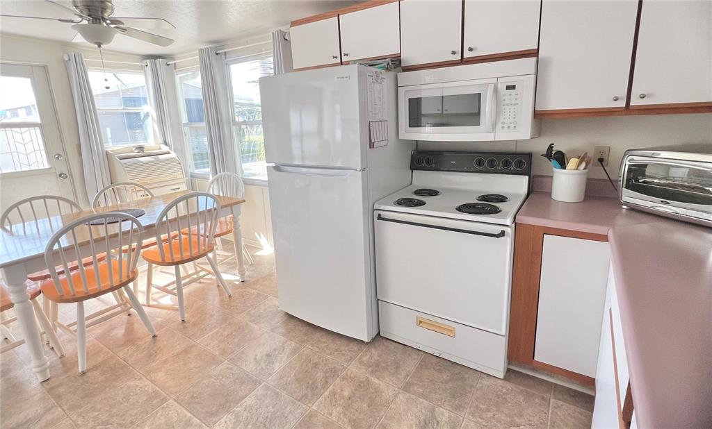 1100 South Belcher Road, Unit 23 Largo, FL 33771 - Photo 11 of 87 a kitchen with stainless steel appliances granite countertop a stove a refrigerator and a microwave