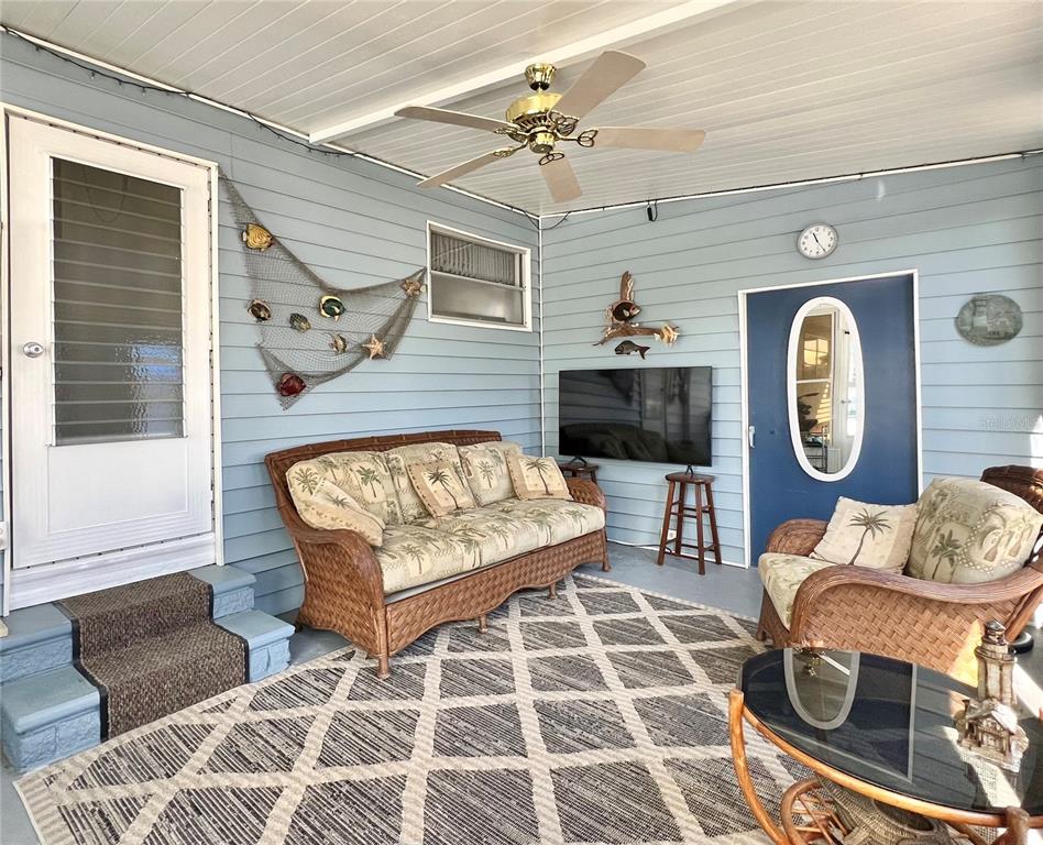1100 South Belcher Road, Unit 23 Largo, FL 33771 - Photo 2 of 87 a living room with furniture a flat screen tv and a wall clock