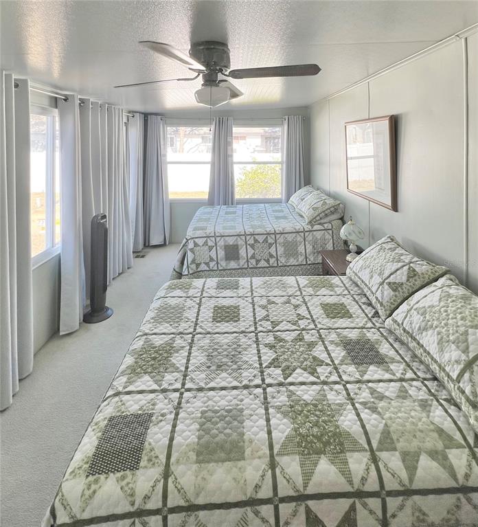 1100 South Belcher Road, Unit 23 Largo, FL 33771 - Photo 24 of 87 a spacious bedroom with a large bed and a chandelier