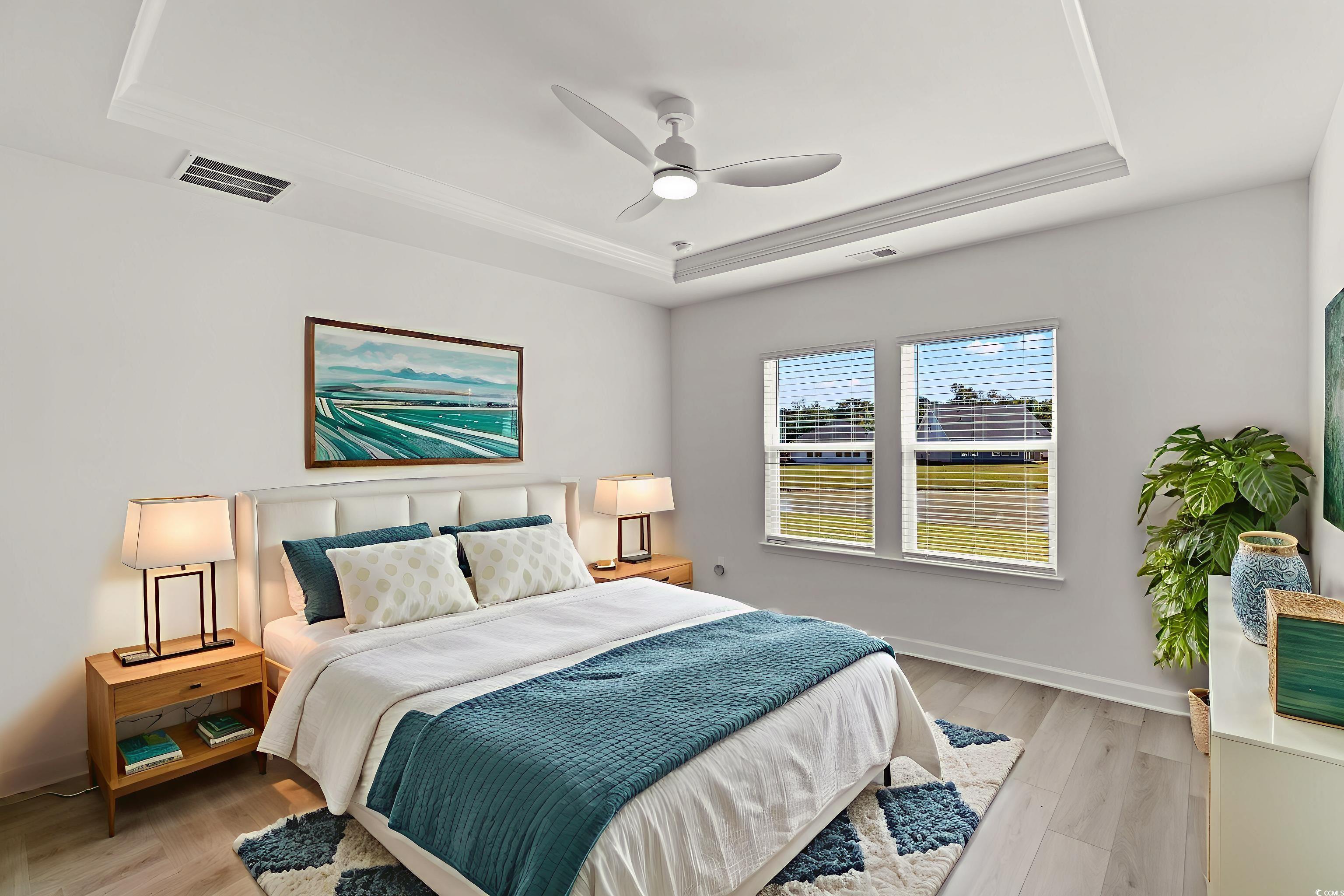 1546 Regal Fern Way Longs, SC 29568 - Photo 11 of 34 Bedroom featuring a tray ceiling, light wood finished floors, and ceiling fan