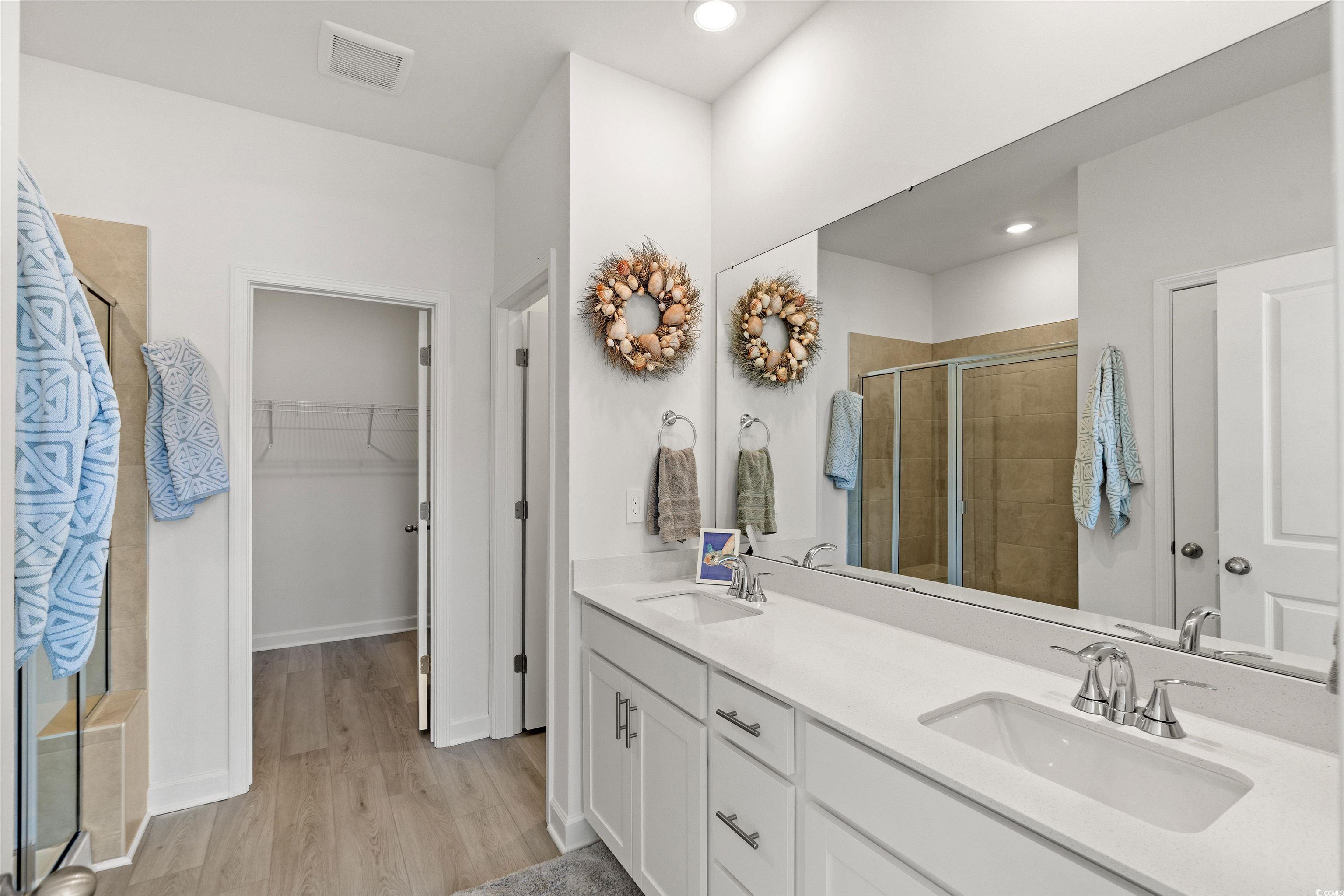 1546 Regal Fern Way Longs, SC 29568 - Photo 14 of 34 Full bathroom with a stall shower, double vanity, light wood-type flooring, a spacious closet, and recessed lighting